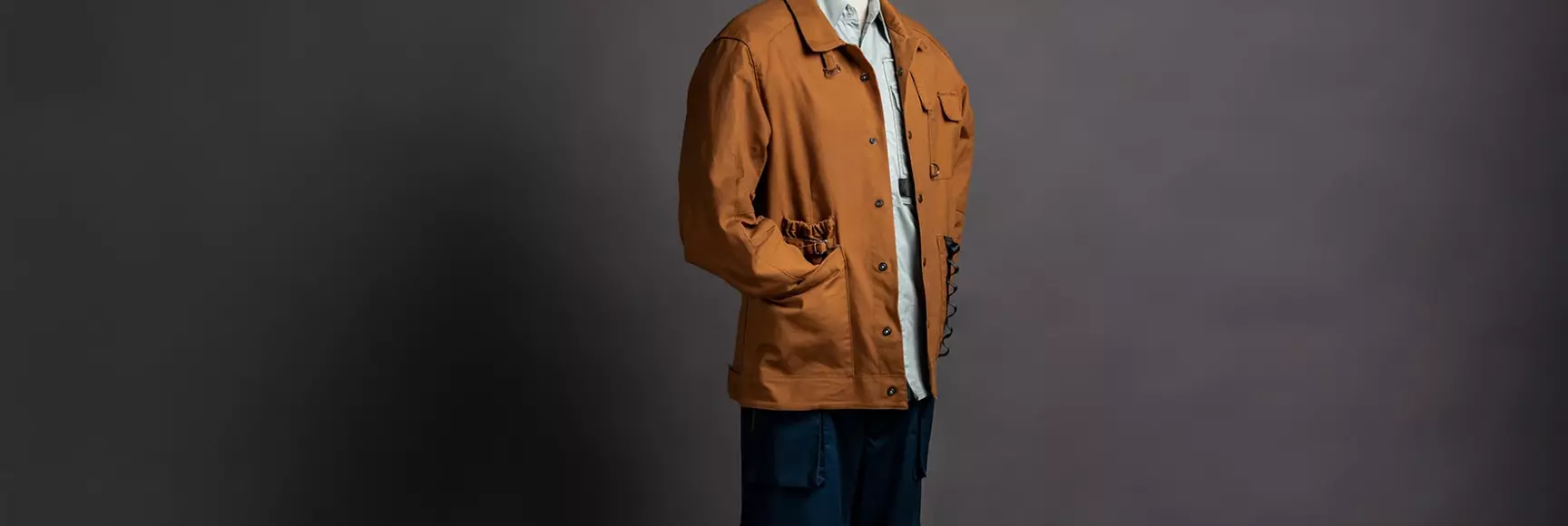 Rust colored utility jacket and navy blue utility pants from The EssentiaAble Collection by Sapphire Finishing Mills With LYCRA® Fiber