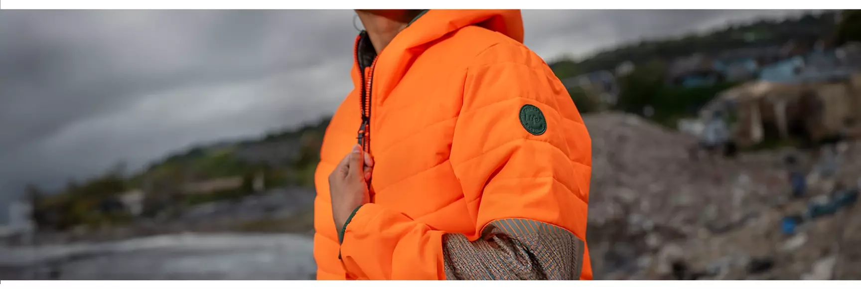 A model wears an orange jacket from PULSAR®