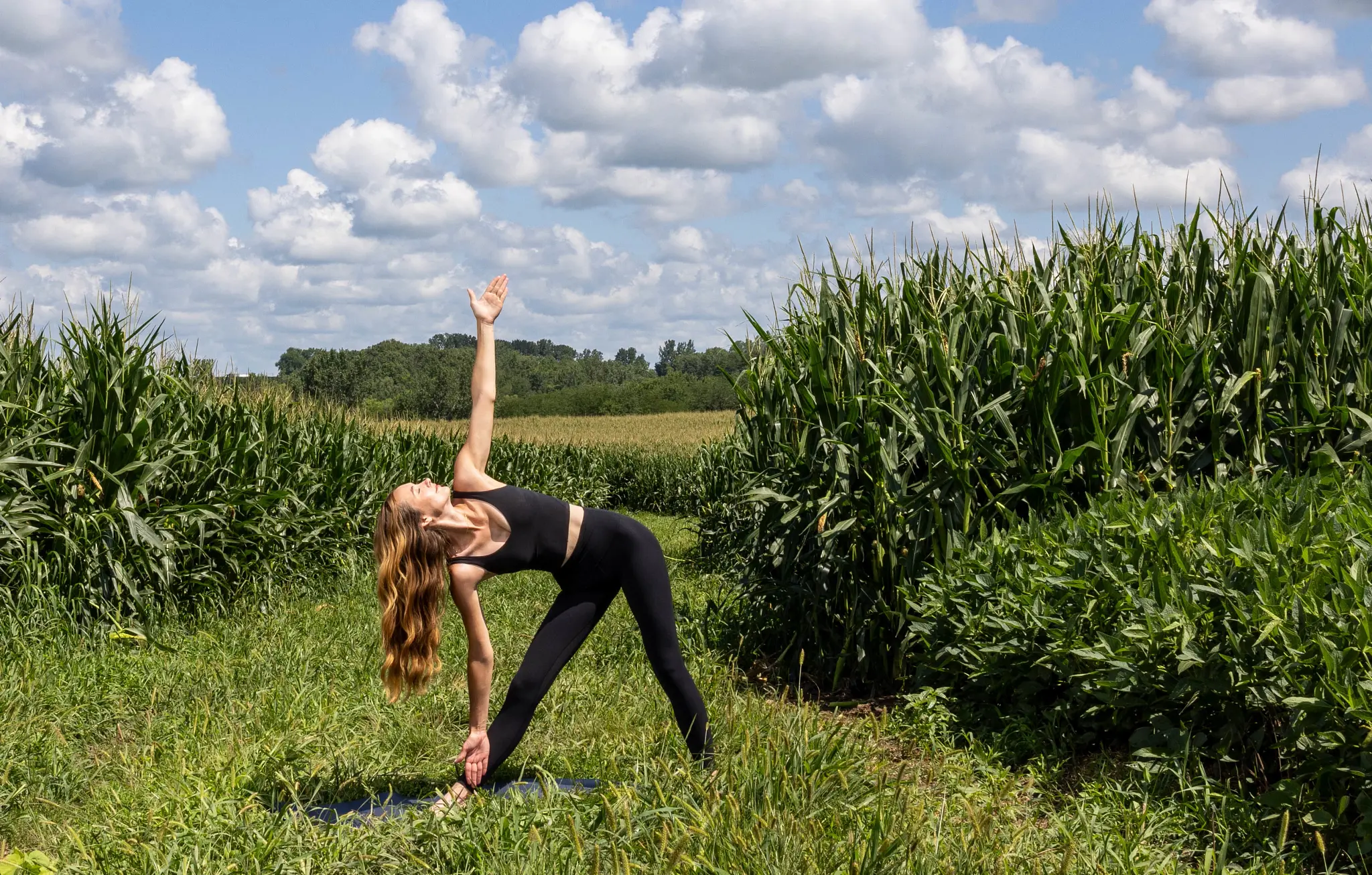 A model in black yoga wear in triangle pose