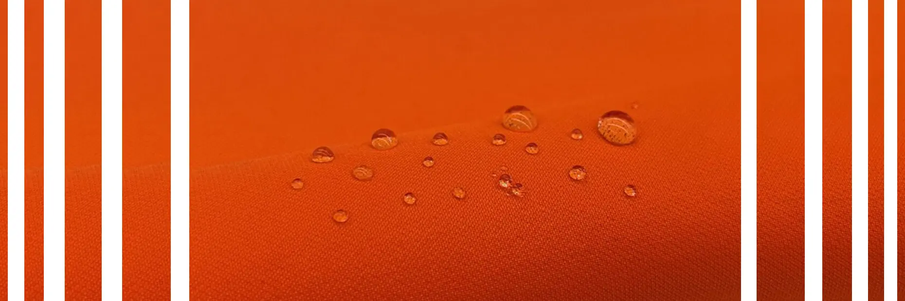 An orange fabric swatch with water beading on top.