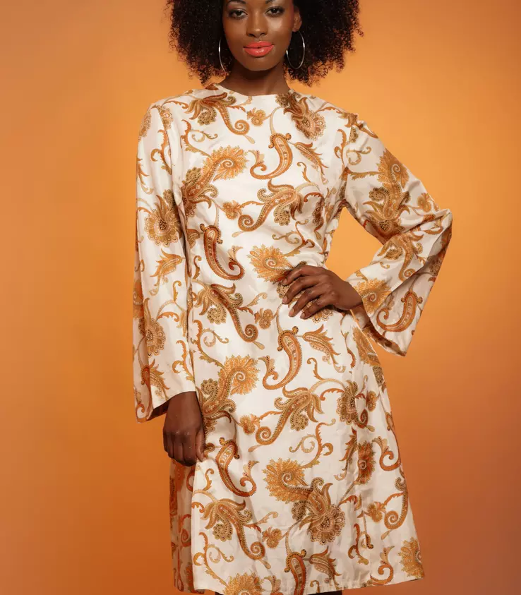 A woman wearing a 1970s dress made with synthetic fibers for easy care and enhanced comfort.